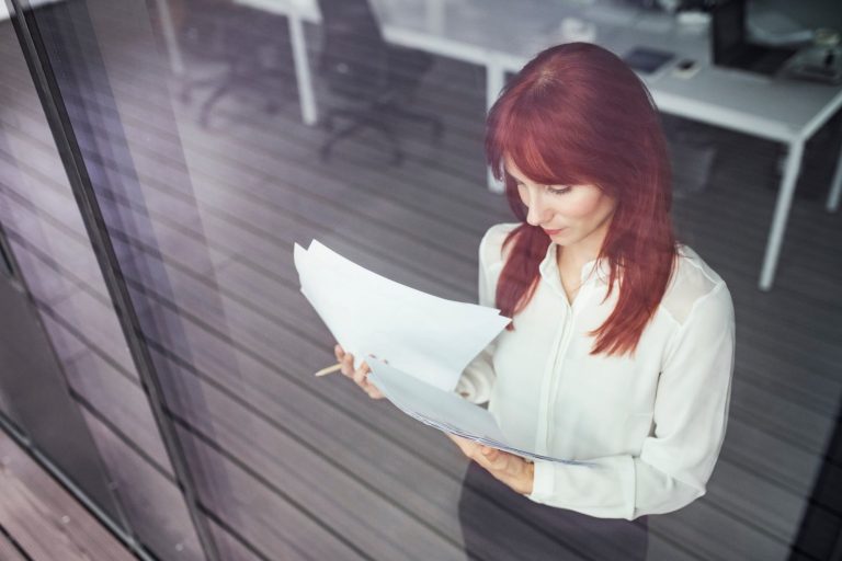 businesswoman-with-documents-in-her-office-PGFNHQ3